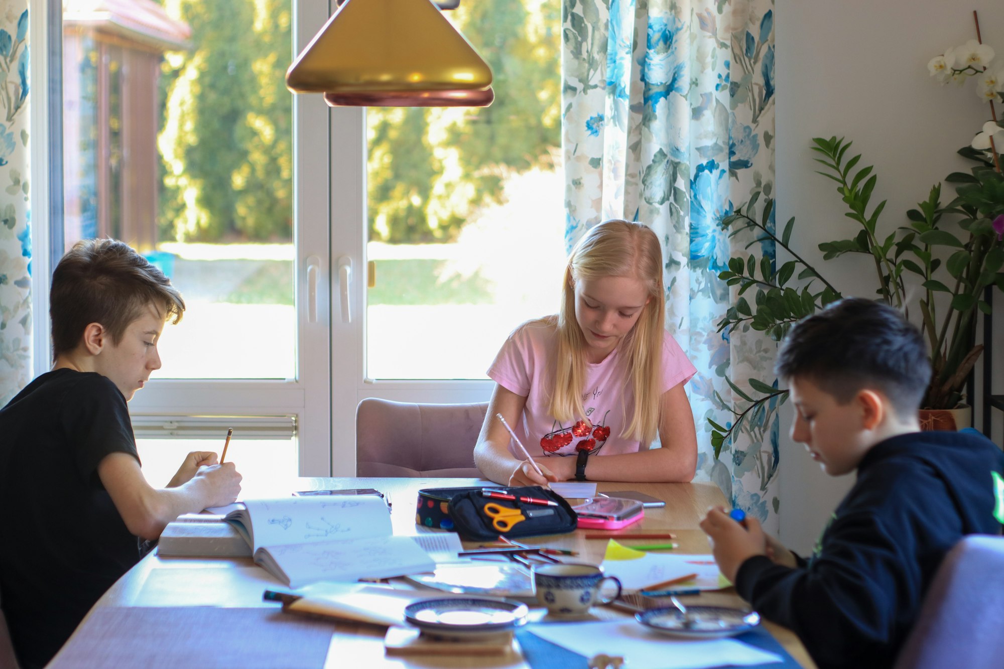 Children at home at the table do their homework, paint pictures, crafts, crafting, family at home.