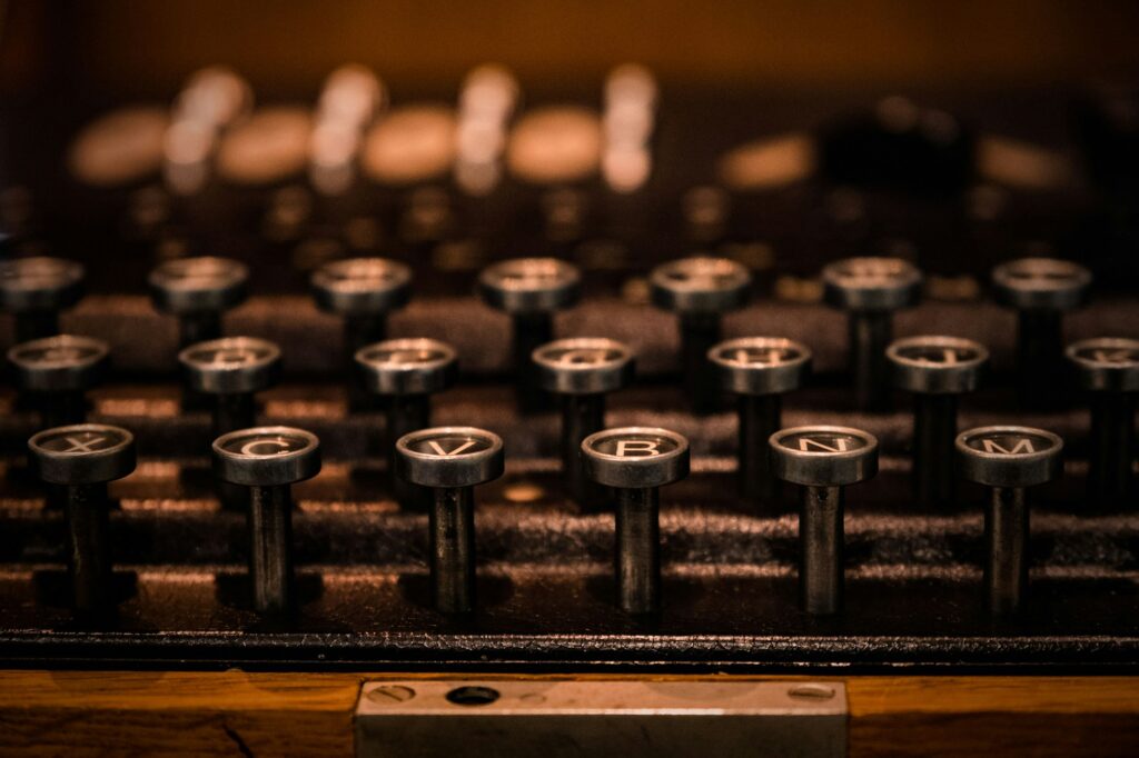 Antique typewriter with a worn wooden casing, missing its keys.