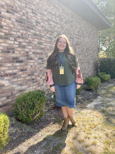 Annie is wearing an absolutely adorable green and pink sweatshirt with cute flowers on the sleeves and a denim skirt.