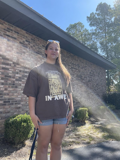 Caitlin is wearing a simple but cute graphic shirt and denim shorts.